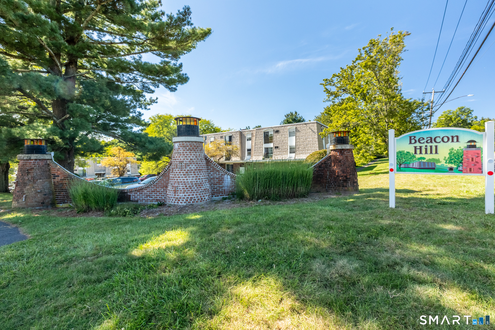 Beacon Hill neighborhood entrance sign beside brick columns topped with lanterns.