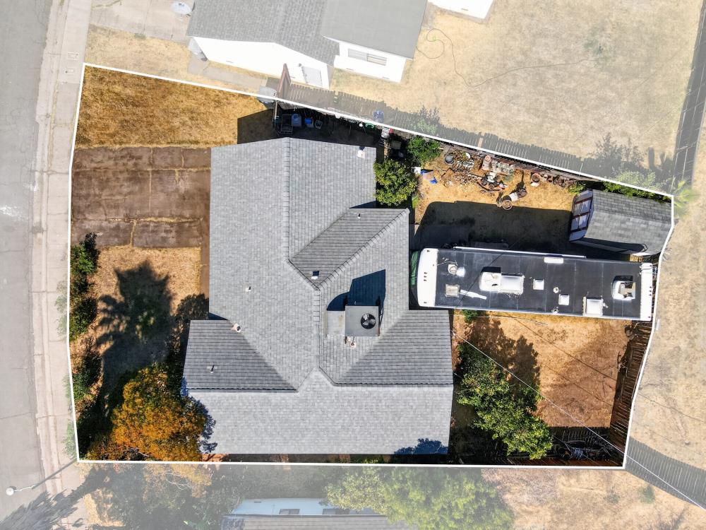 Aerial view of the home and property, with an RV parked beside the house.