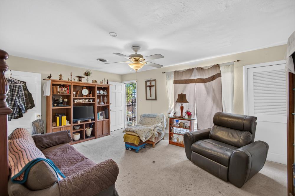 Living room with a leather recliner, quilted sofa, and large wooden bookcase.