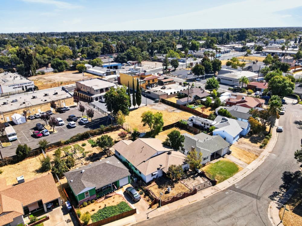 Aerial view of homes and nearby shops along tree-lined streets.
