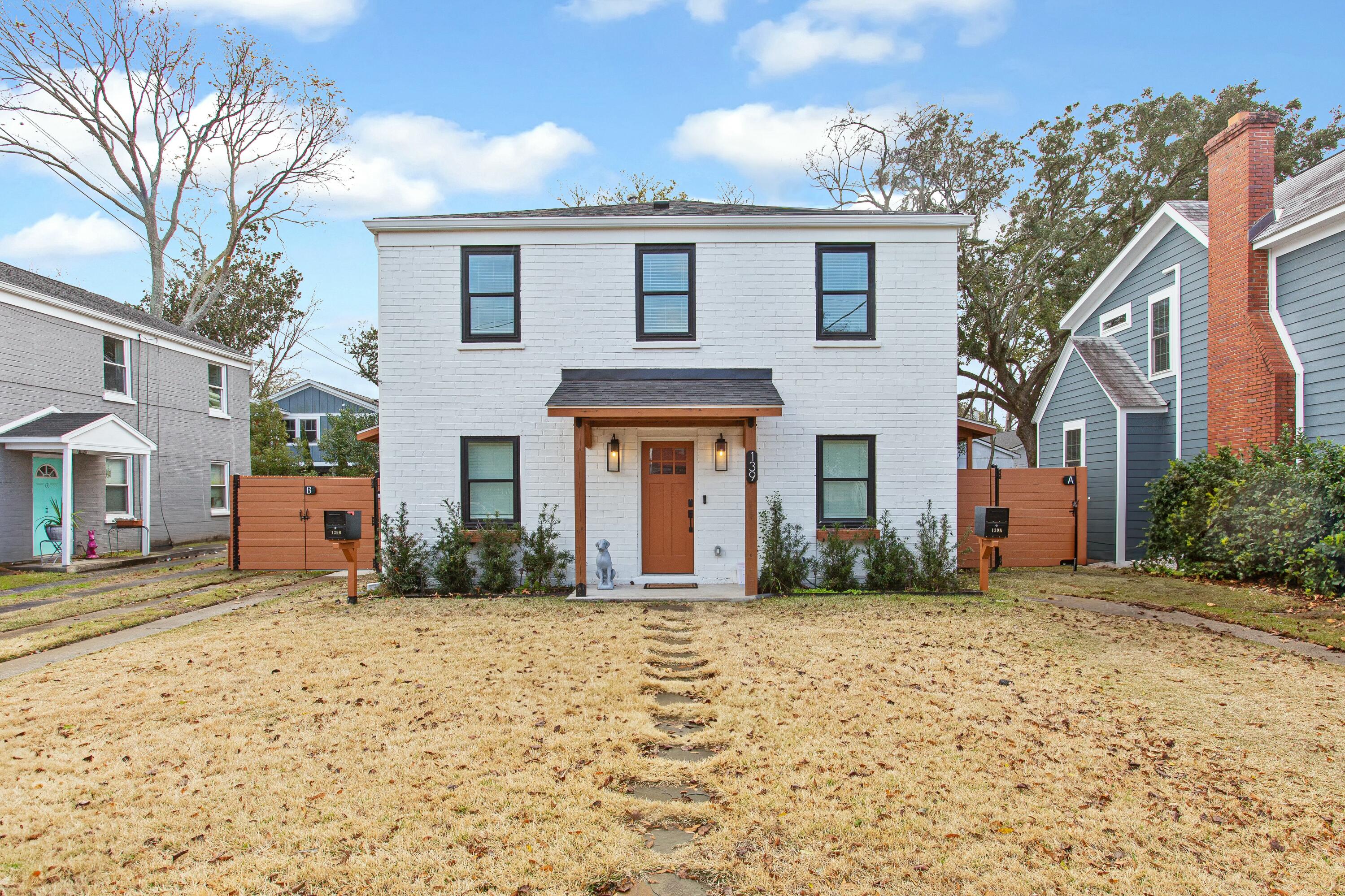 White two-story brick house with a wood front door and separate gates marked A and B.