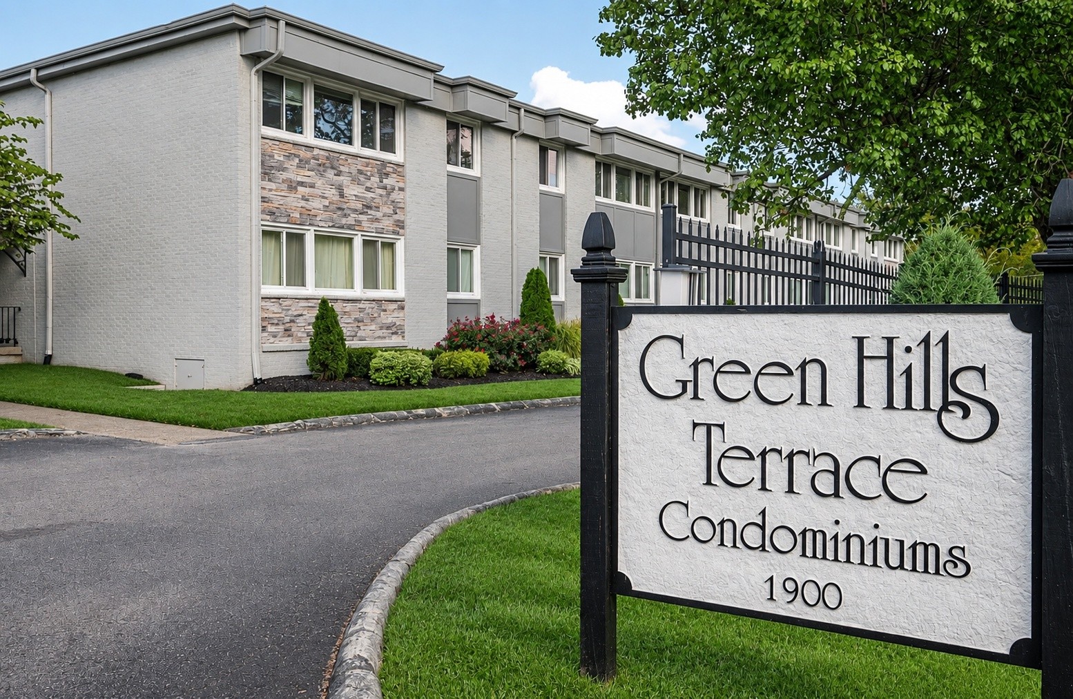 Green Hills Terrace condominiums beside the entrance sign displaying the property name and 1900.