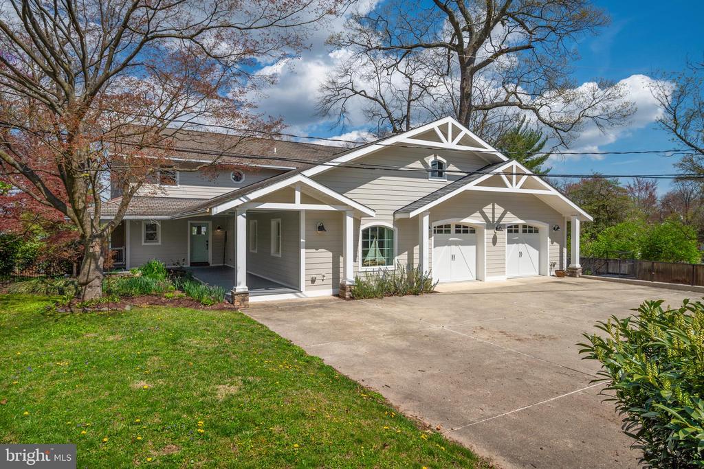 Two-story gray home with multiple gables, a two-car garage, and a wide driveway.