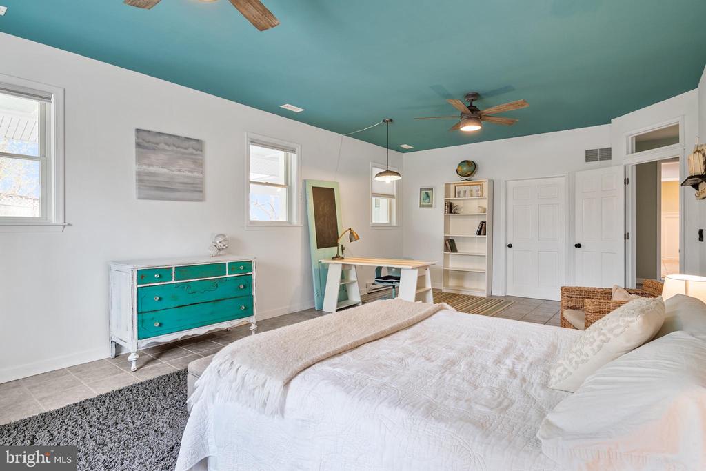 Bedroom with a white bed, turquoise ceiling, and turquoise dresser.