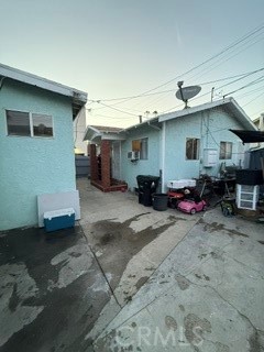 Light blue residential buildings surround a concrete courtyard with bins and outdoor equipment.