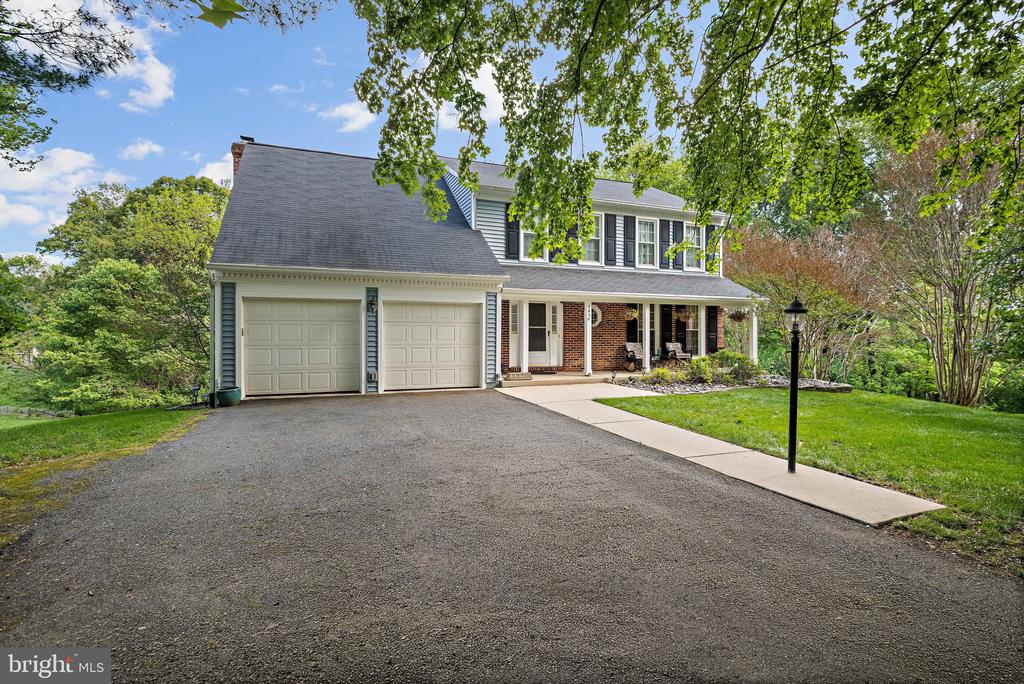 Two-story home with brick-and-siding façade, two-car garage, and broad driveway.