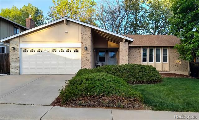 Single-story house with a two-car garage, brick accents, and landscaped front yard.