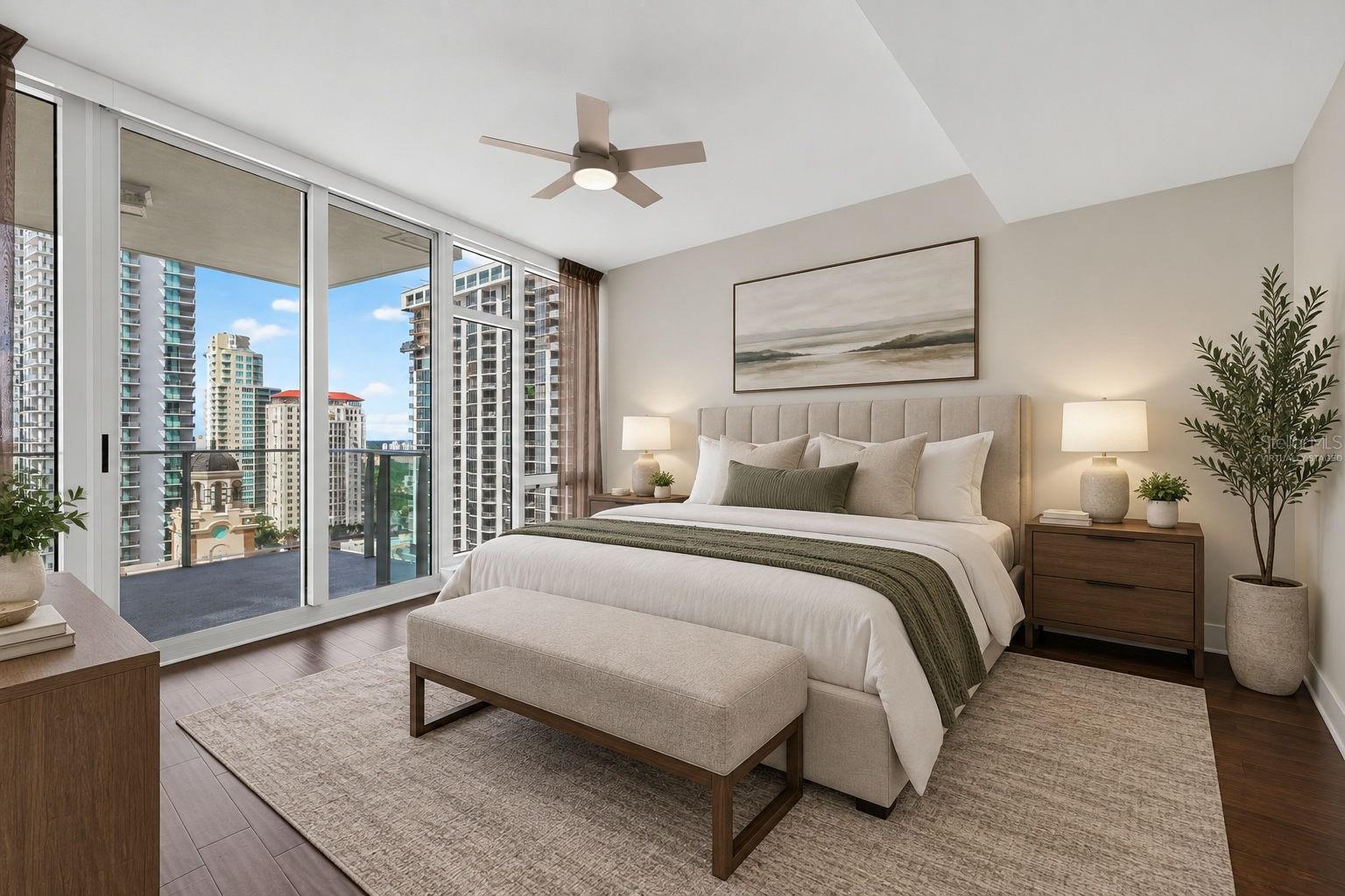 Staged condo bedroom with a king bed and floor-to-ceiling windows overlooking downtown buildings.