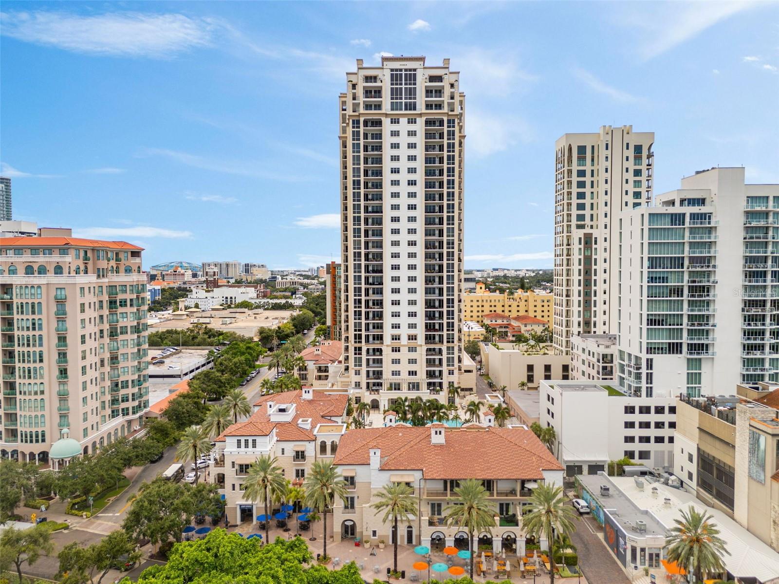 Downtown St. Petersburg skyline with a tall beige condominium tower centered among neighboring buildings.