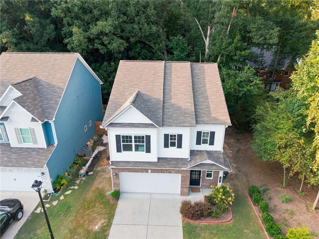 Aerial view of a white two-story home with an attached garage and concrete driveway.