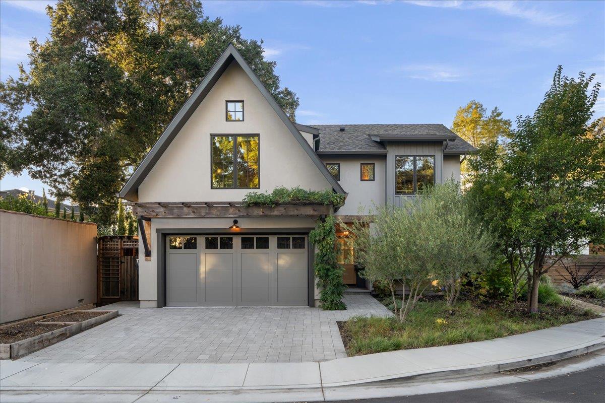 Two-story gray home with a steep front gable, wide garage, and paved driveway.