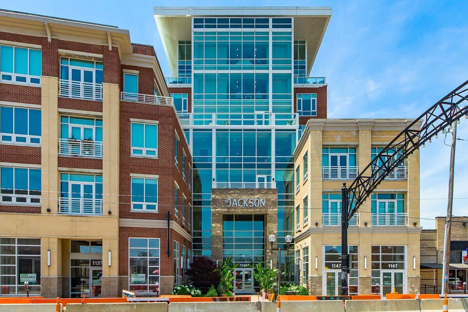 The Jackson residential building with a glass-fronted entrance, brick wings, and balconies.