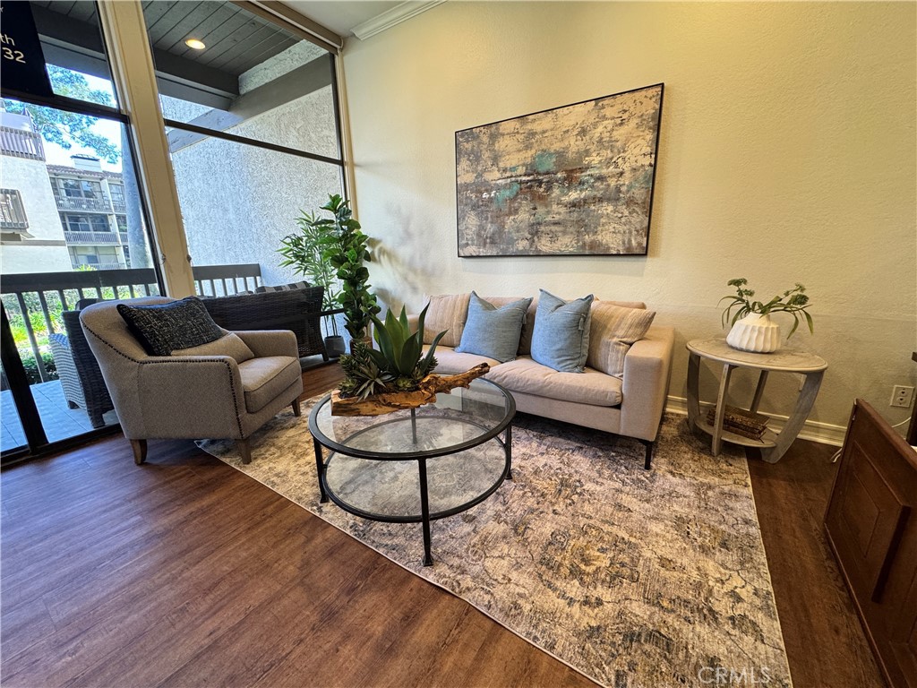 Furnished living room with a beige sofa, glass coffee table, and sliding doors to a balcony.