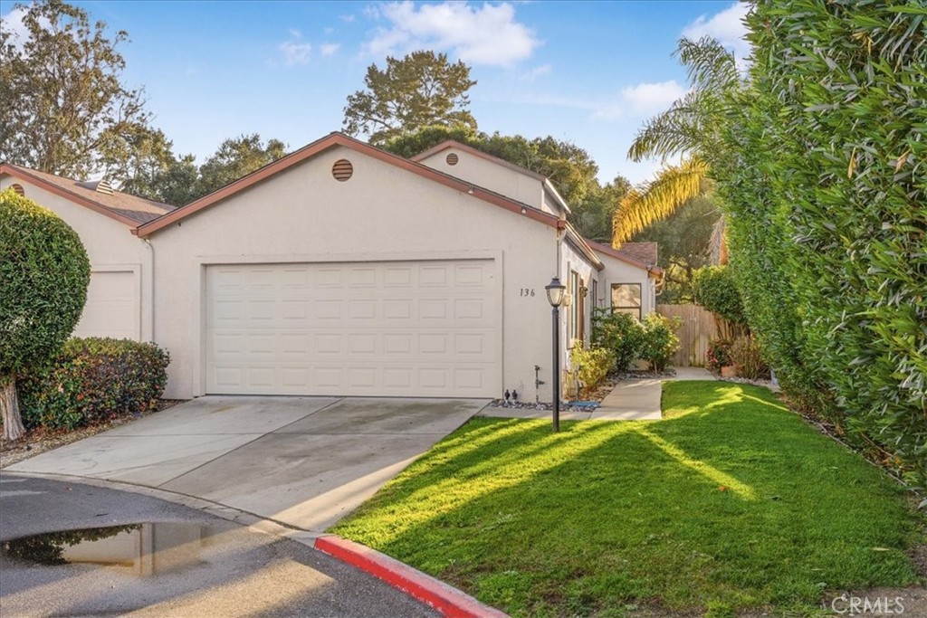 Home exterior with a two-car garage, concrete driveway, and neatly landscaped lawn.