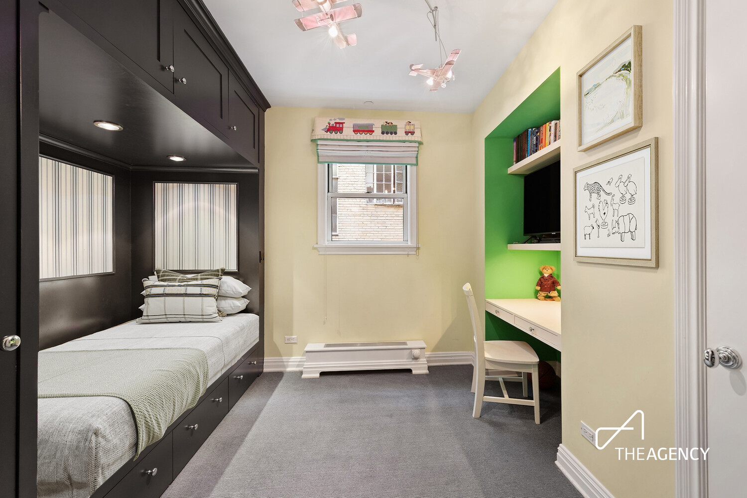 Bedroom with a built-in bed, green desk nook, and airplane ceiling lights.