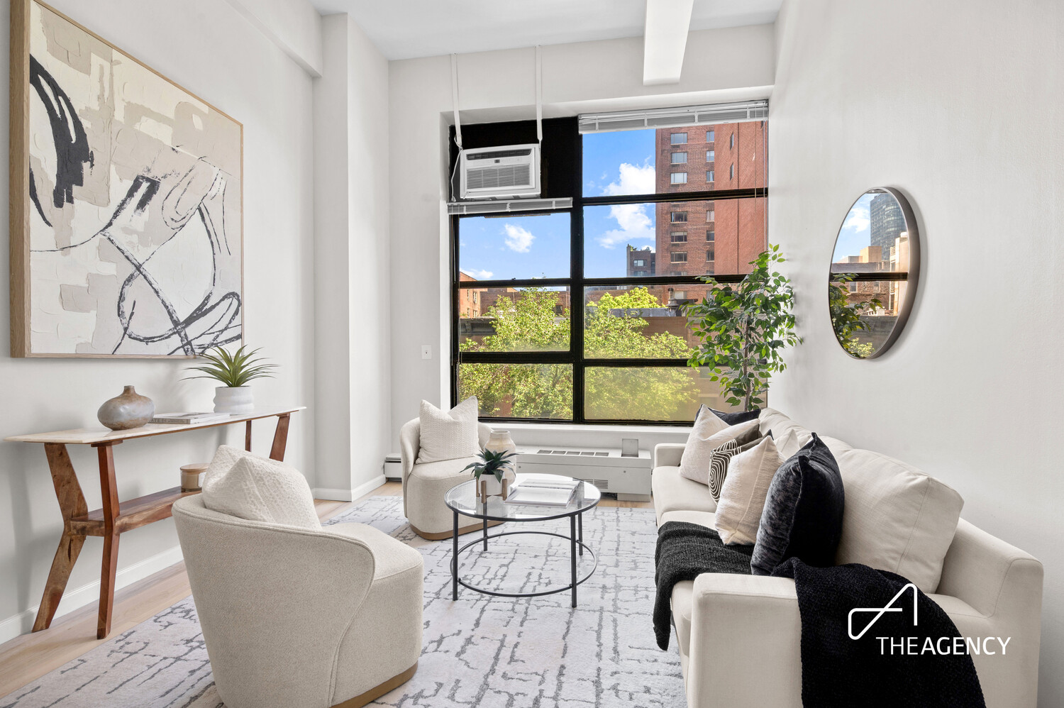 Bright living room with a large grid window, neutral seating, and an urban view.