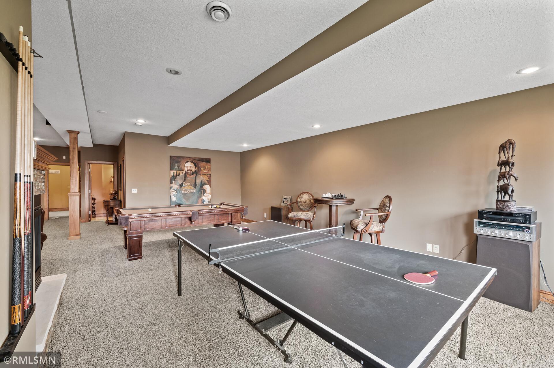 Recreation room with a ping-pong table in front of a pool table.