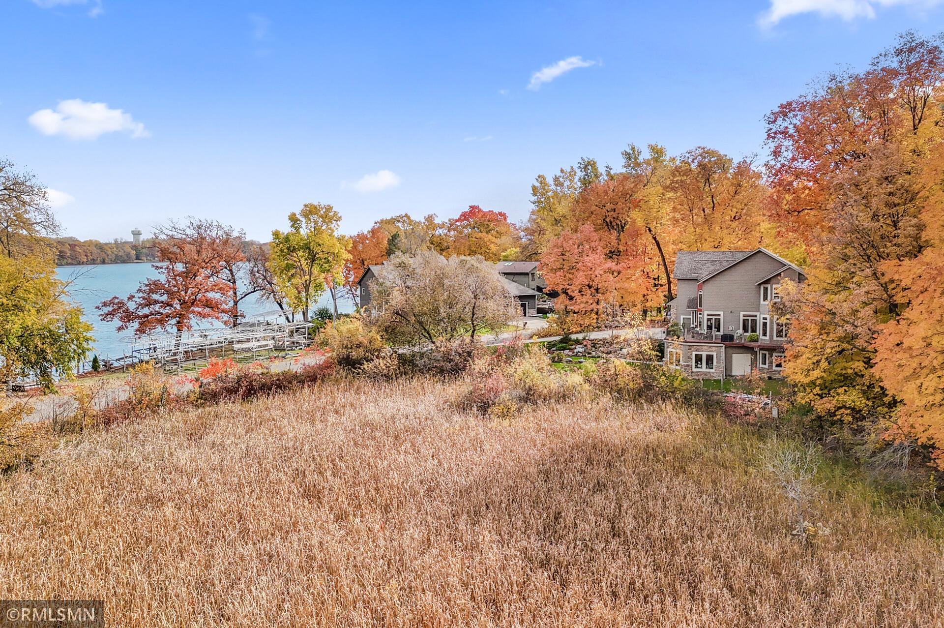 Lakeside homes beside the water, surrounded by autumn foliage and tall grasses.