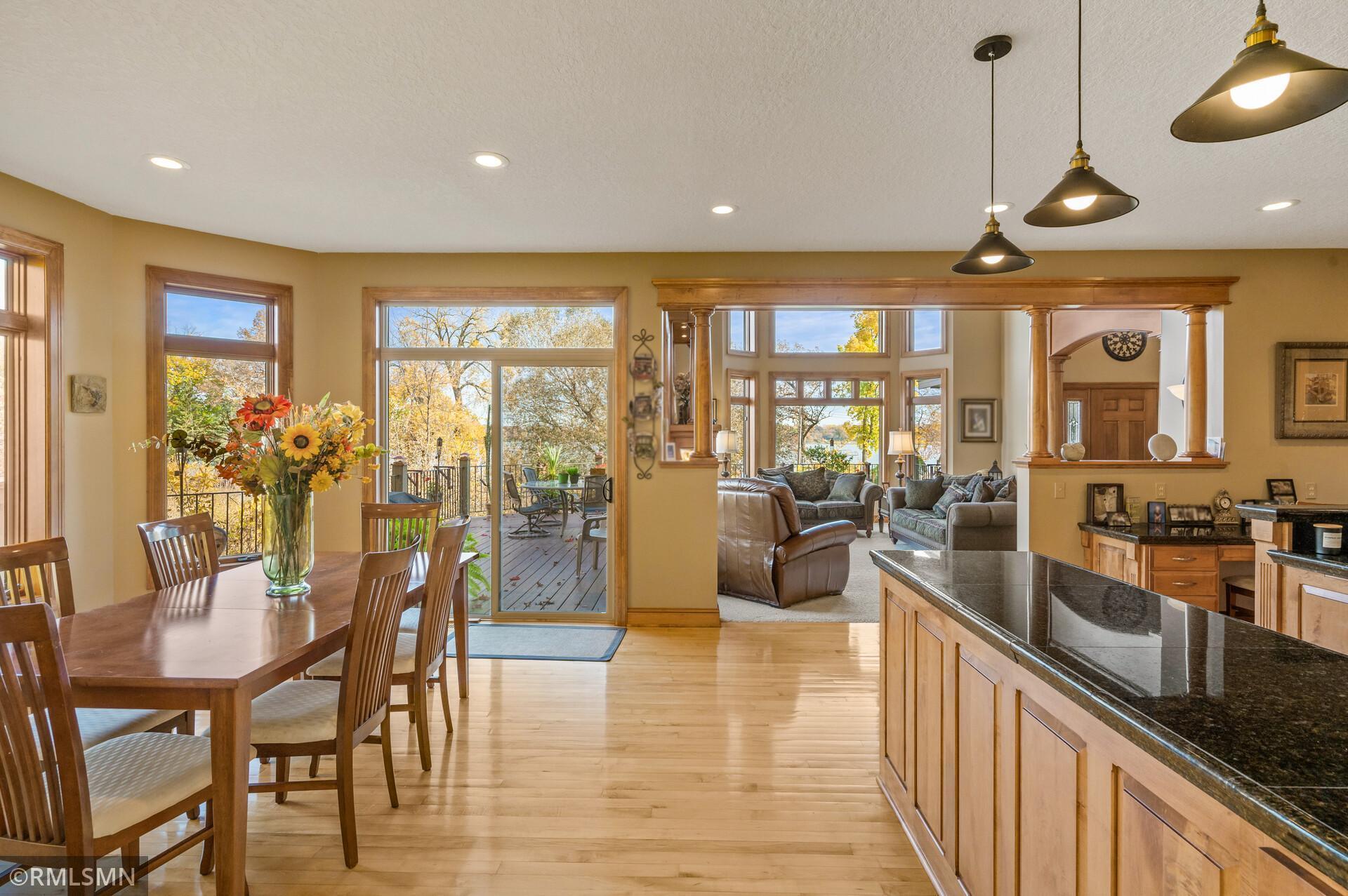 Open dining room and kitchen with a granite island, large windows, and a view toward the living room.