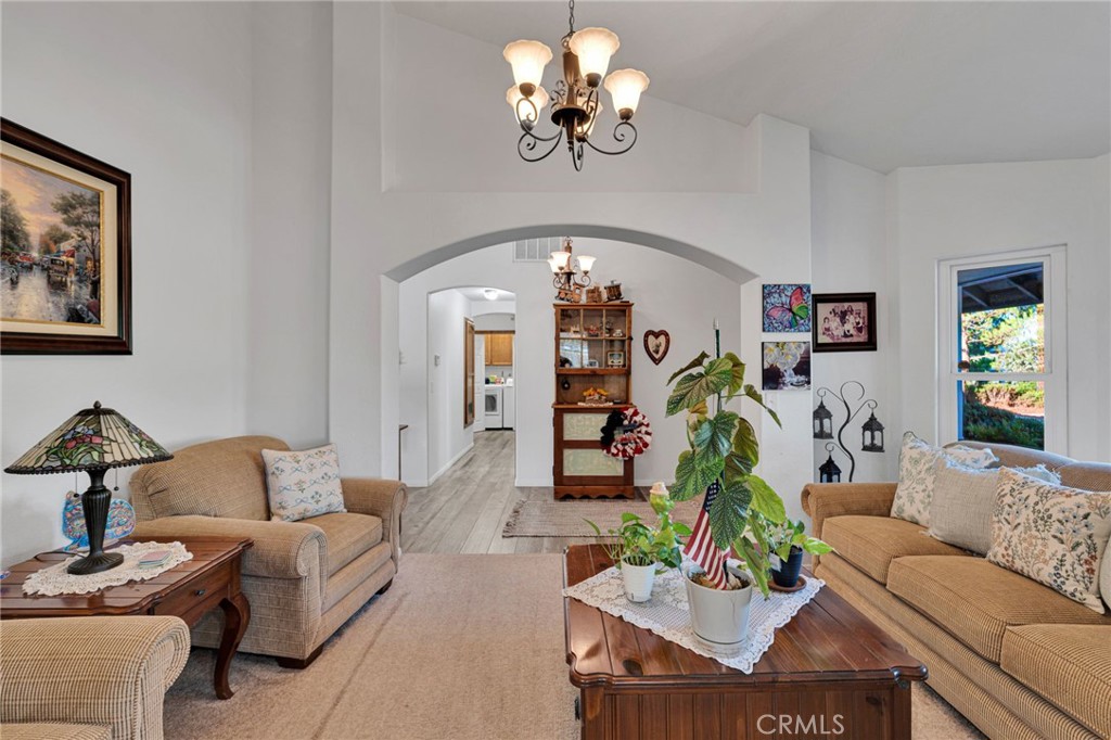 Living room with two sofas, a wood coffee table, and a wide archway toward the kitchen.