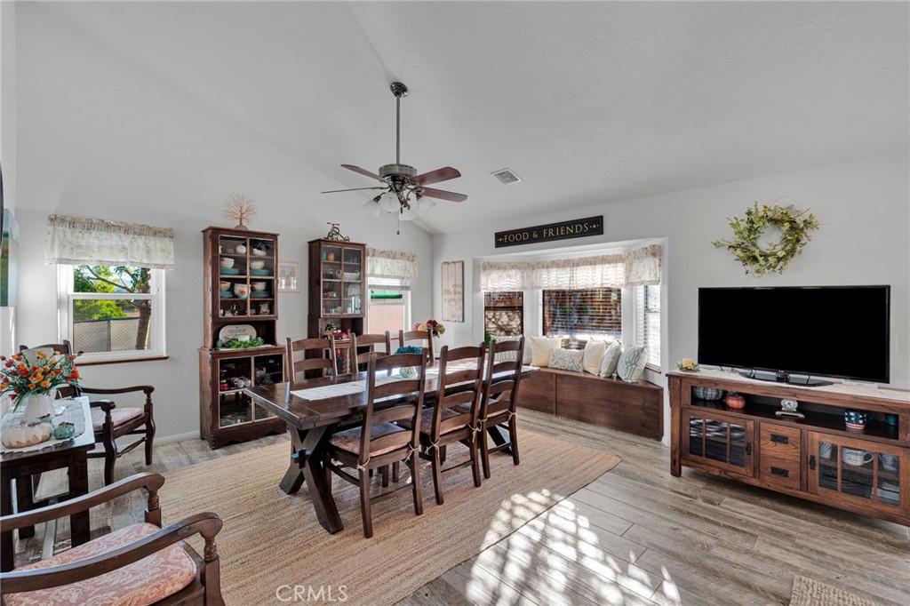 Dining room with a dark wood table, display cabinets, and a window bench.