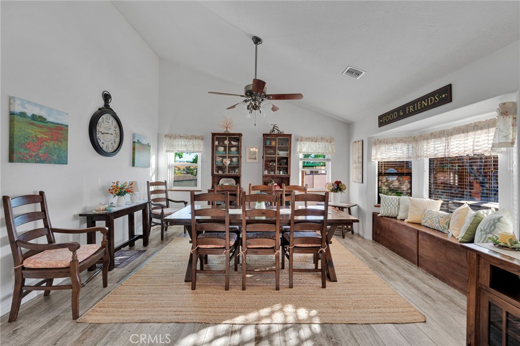 Dining room with a large wooden table, matching chairs, and a window bench.