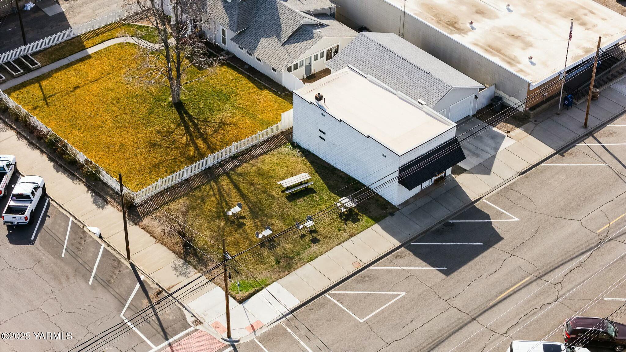 Aerial view of 622 Second Ave, with a large fenced lawn and connected buildings.