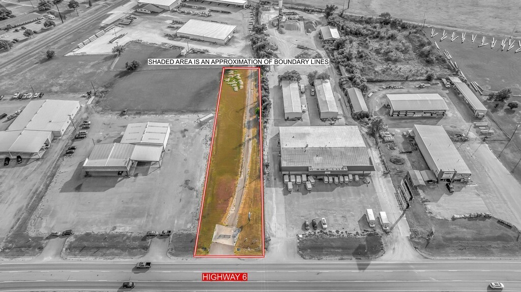 Narrow commercial parcel outlined in red along Highway 6, surrounded by industrial buildings.