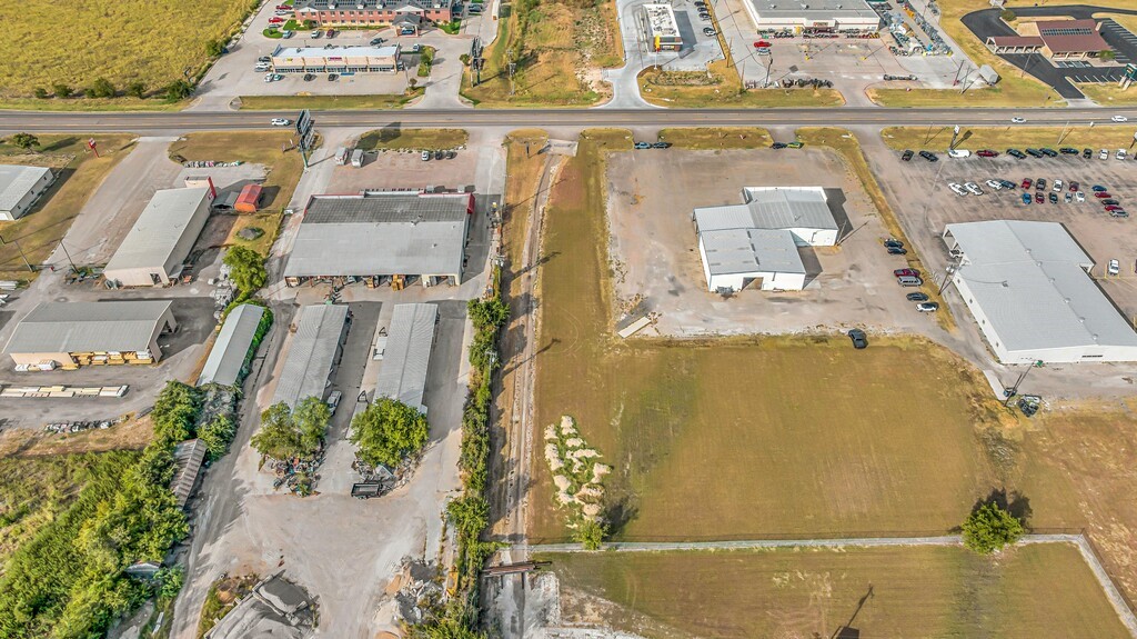 Vacant commercial land beside Highway 6, surrounded by warehouses and businesses.