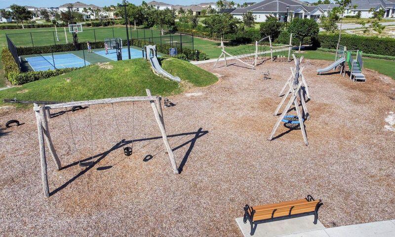 Playground with swings, slides, climbing equipment, and a fenced basketball court.