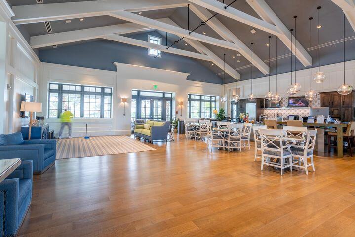 Open-plan living and dining area with exposed beams, wood floors, and a kitchen island.