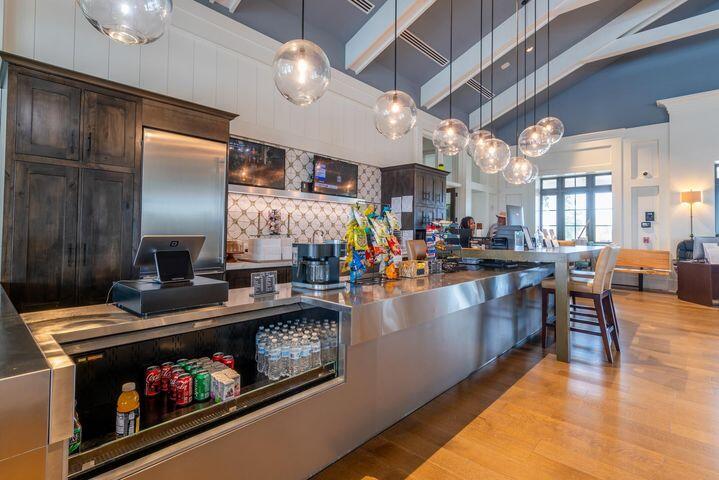 Spacious kitchen with a long stainless-steel island and glass pendant lights.