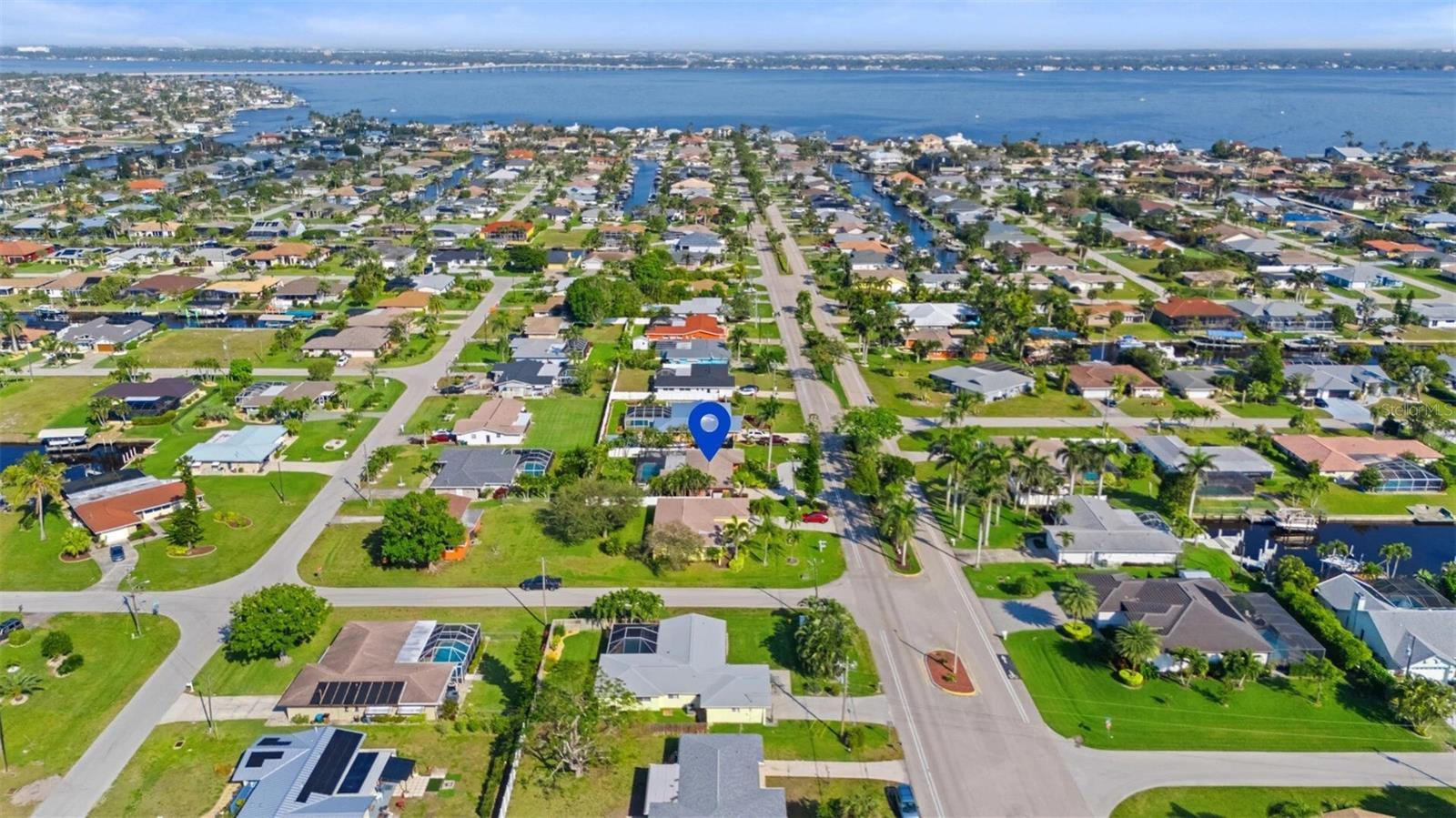 Aerial view of the marked Cape Coral home among canals and waterfront homes.