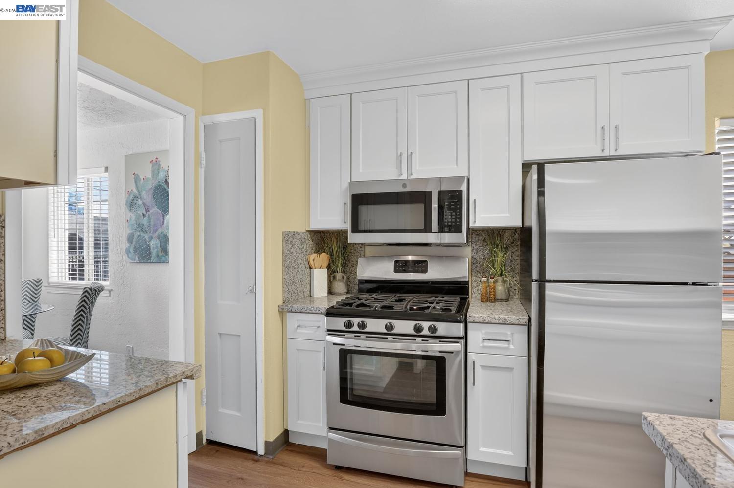 Kitchen with white cabinets, granite counters, and stainless-steel appliances.