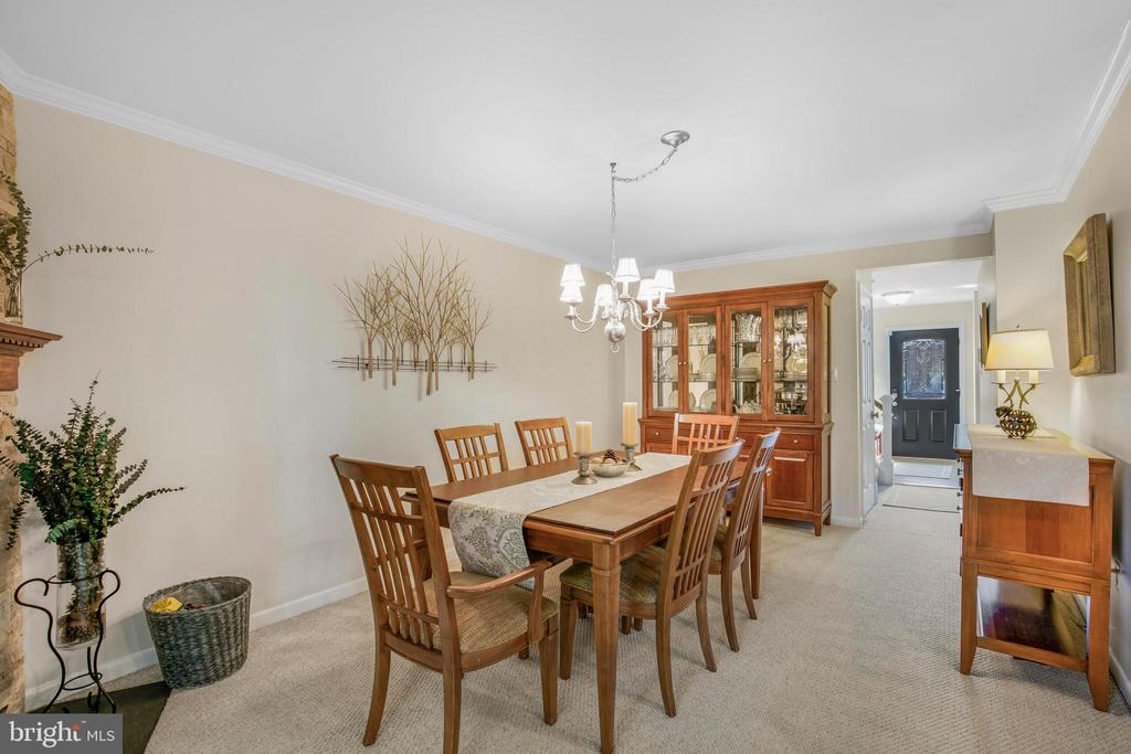 Dining room with a wooden table and chairs, glass-front china cabinet, and chandelier.