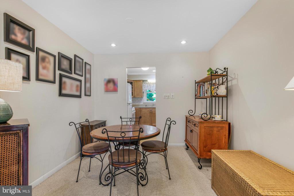 Dining room with a round table, wrought-iron chairs, and wooden cabinets.