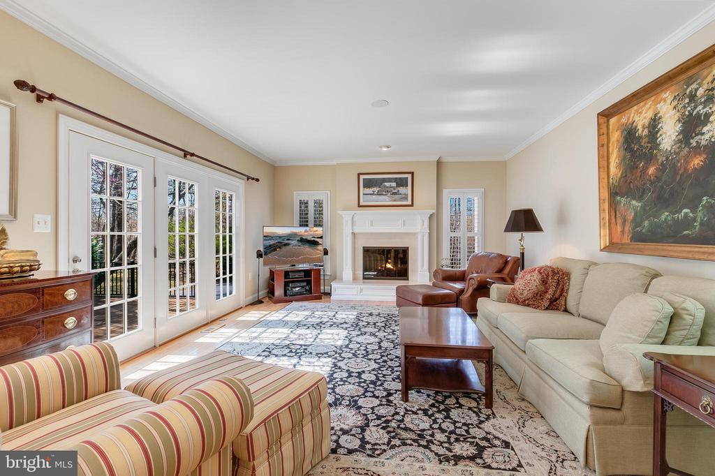 Living room with a white fireplace, French doors, and a large patterned rug.