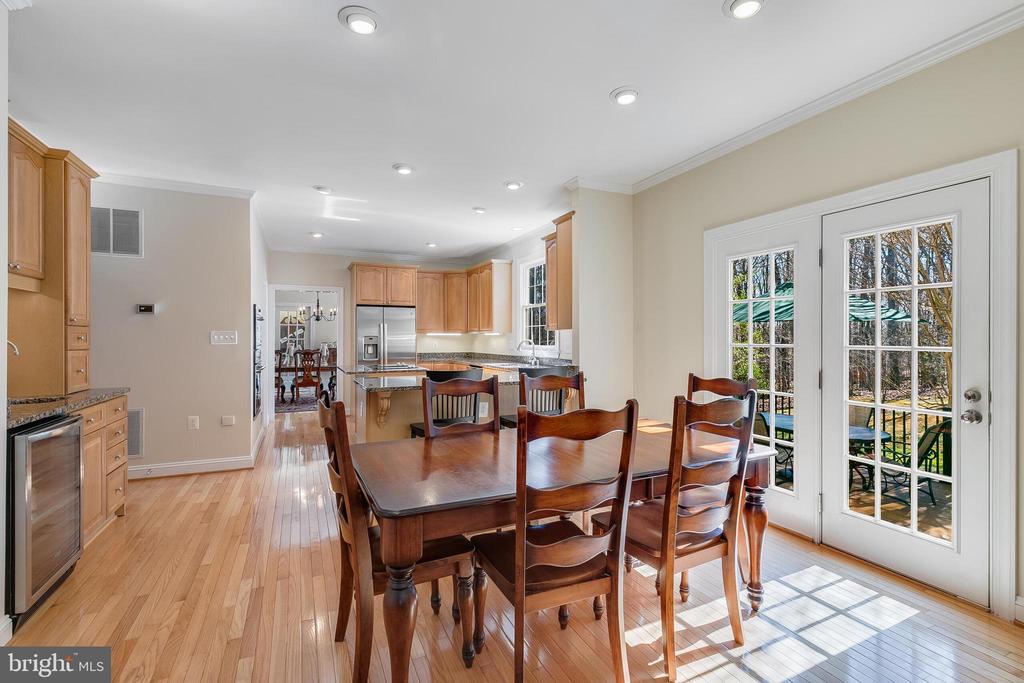 Dining room with a large wooden table, hardwood floors, and French doors to the patio.
