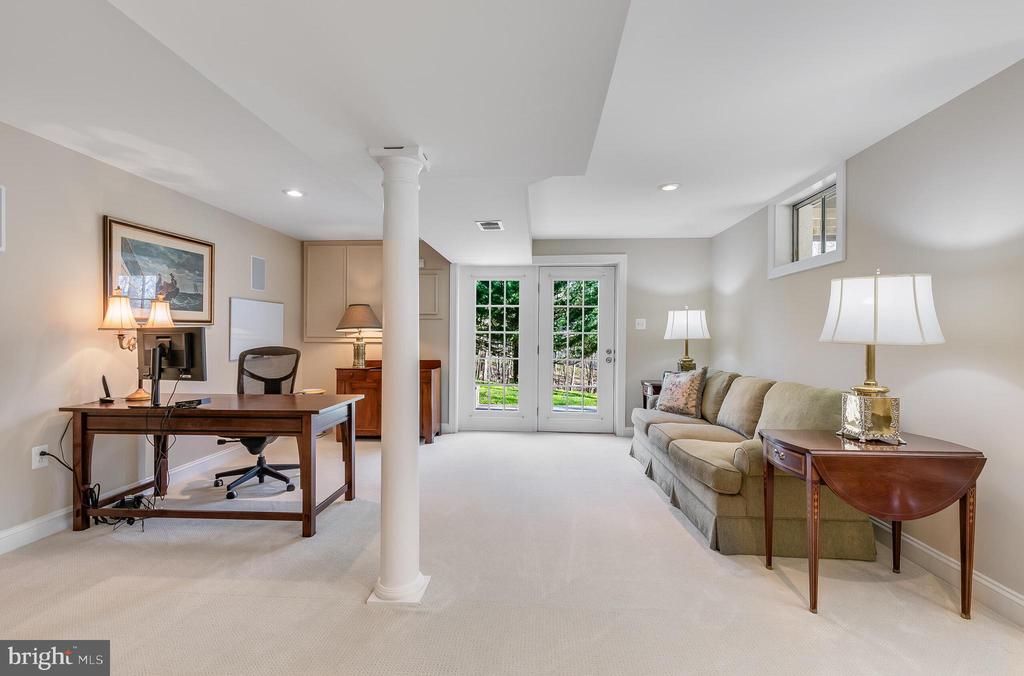 Furnished sitting room and home office with a central column and glass doors to the yard.