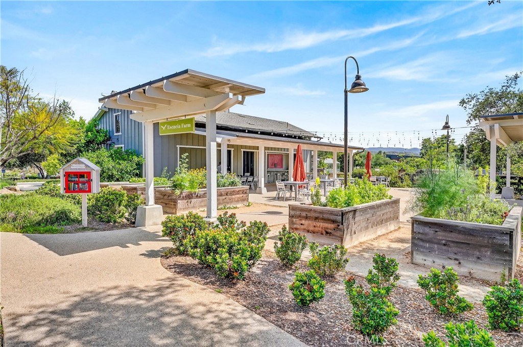 Community farm patio with raised garden beds, pergola, and outdoor seating.