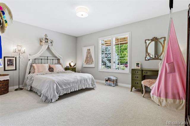 Bedroom with a white canopy bed, shuttered window, and olive-green dresser.