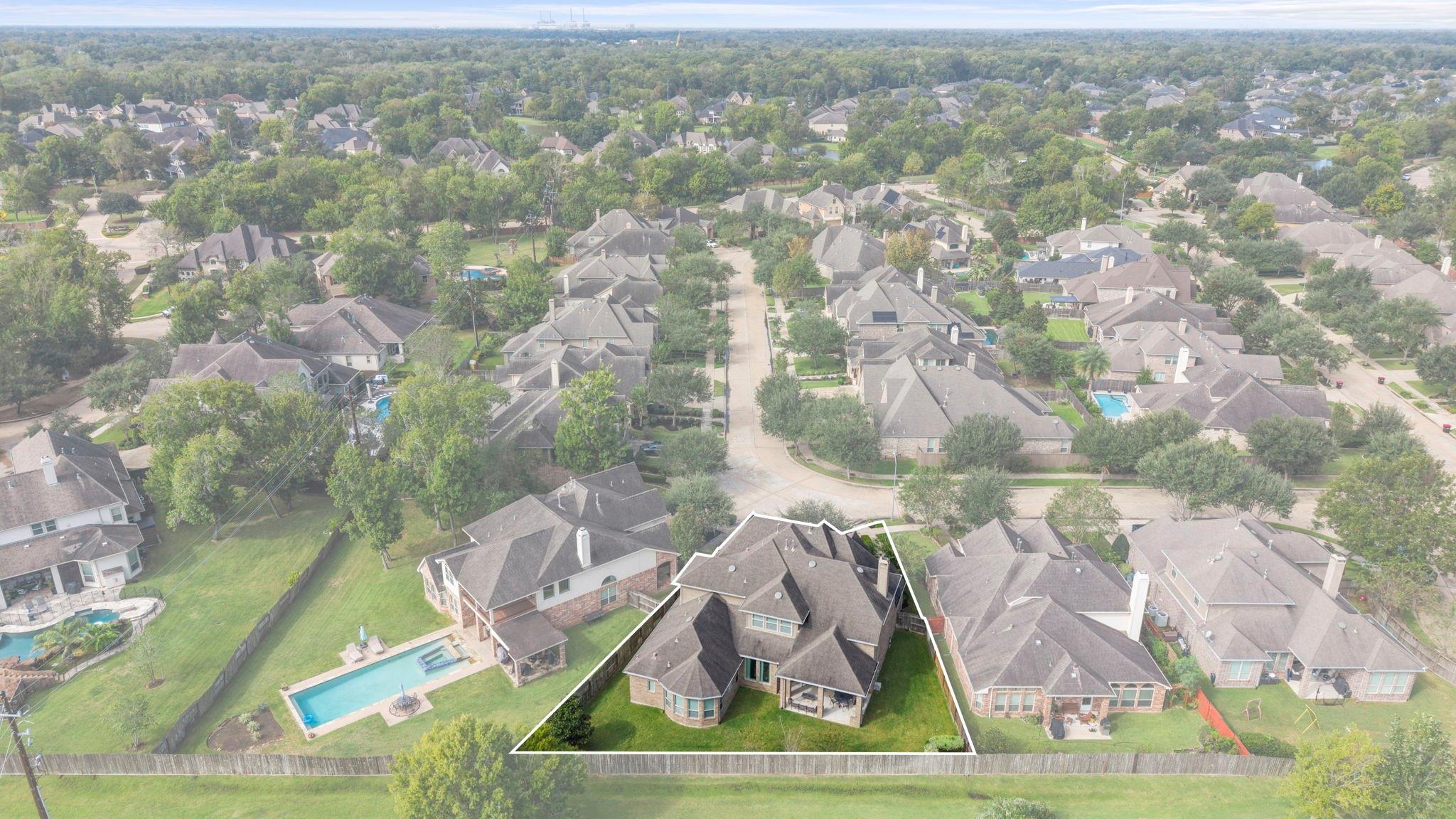 Aerial view of an outlined suburban home and fenced yard with a swimming pool.