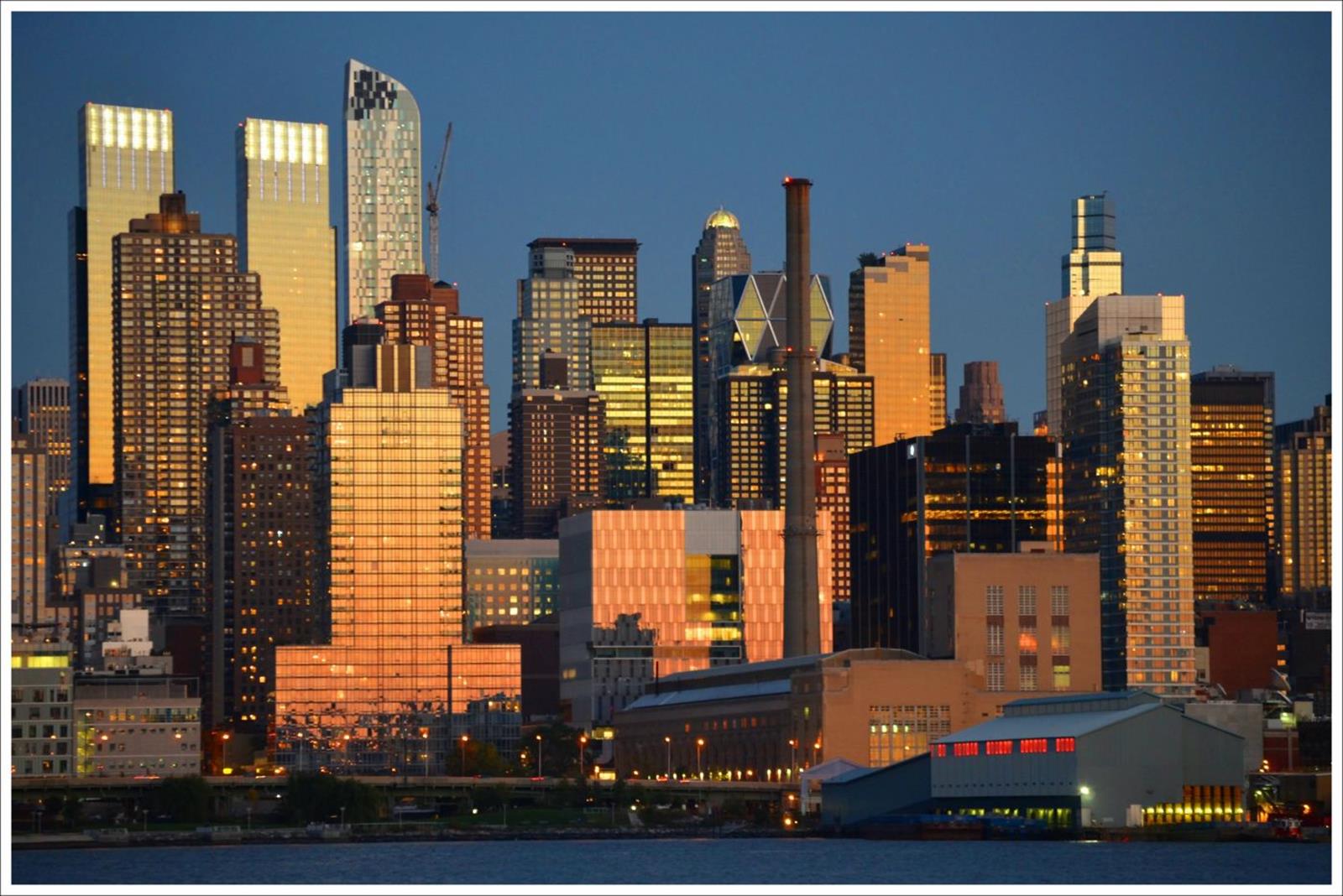 Manhattan skyline glowing at sunset across the waterfront.