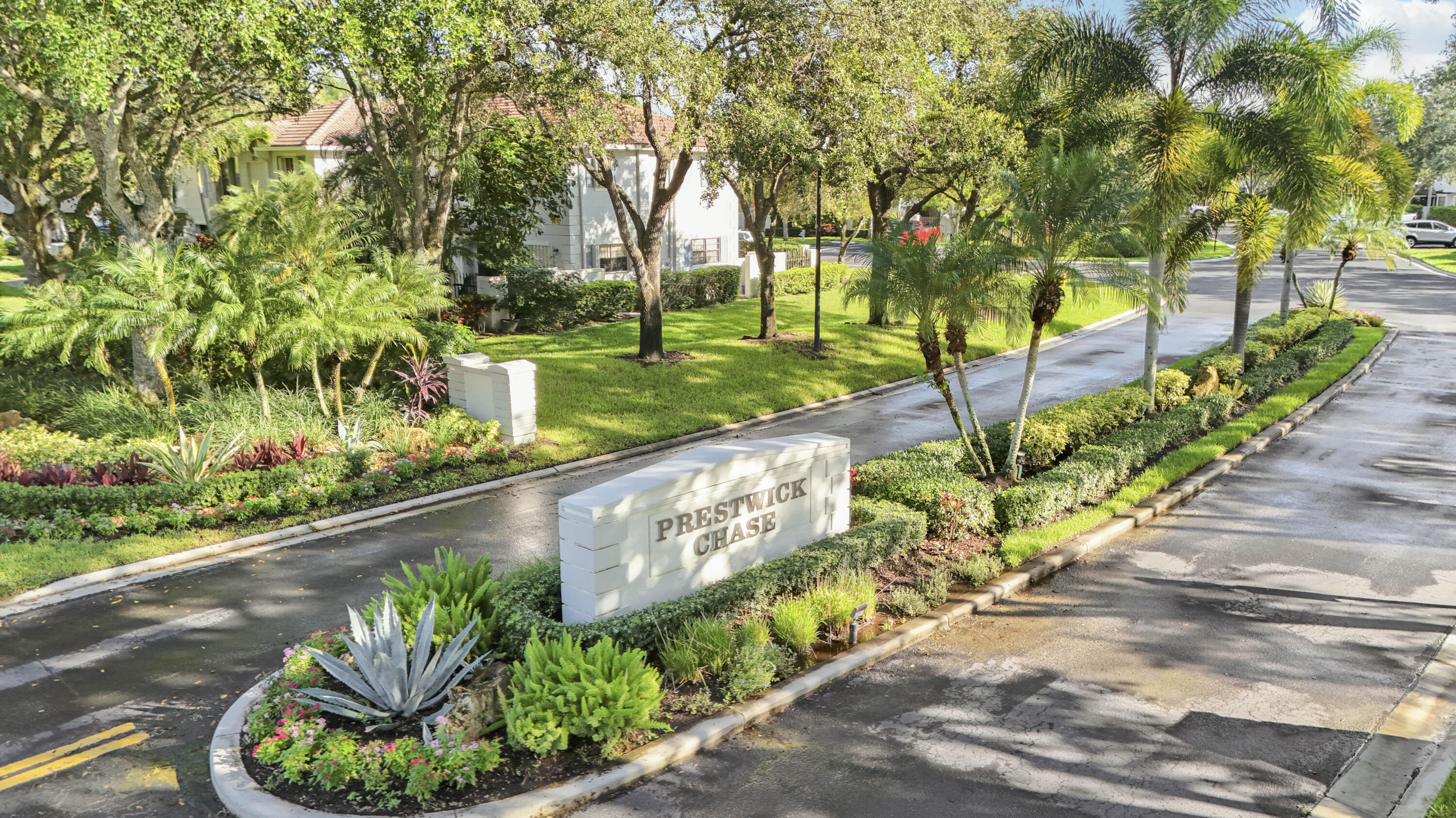 Prestwick Chase community entrance sign amid tropical landscaping.