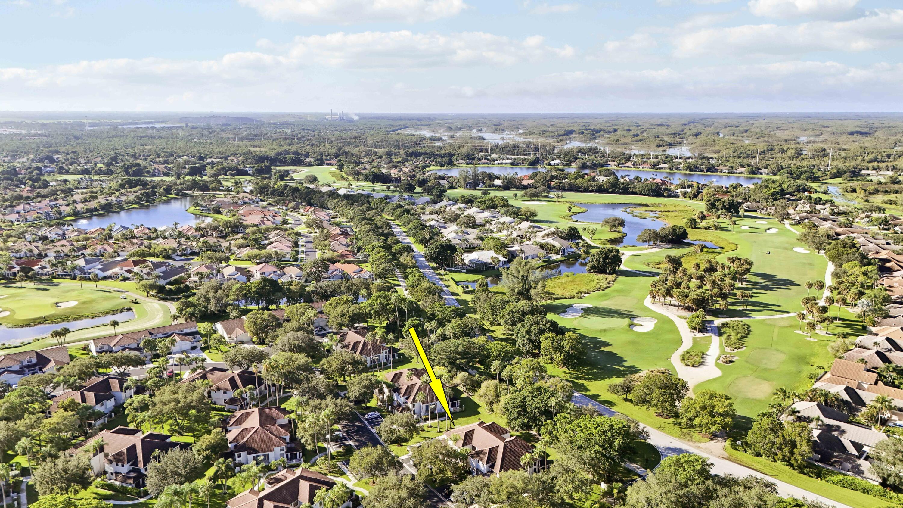 Aerial view of the home beside a golf course, marked with a yellow arrow.