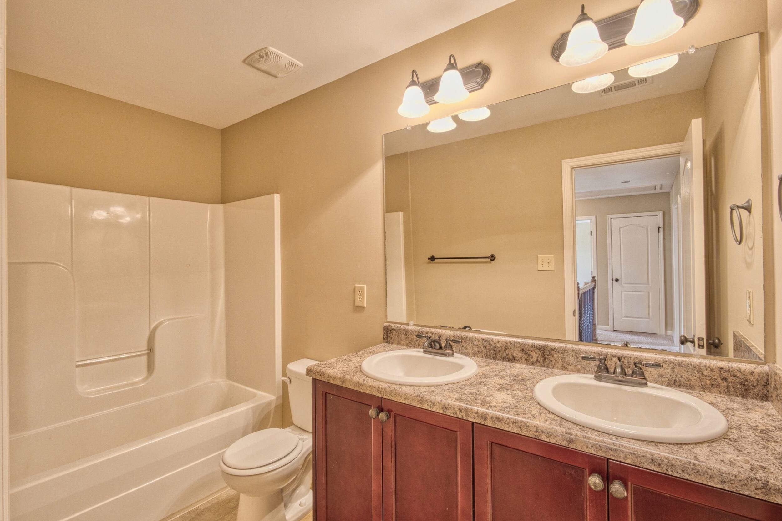 Bathroom with a tub and shower and a double-sink granite vanity.