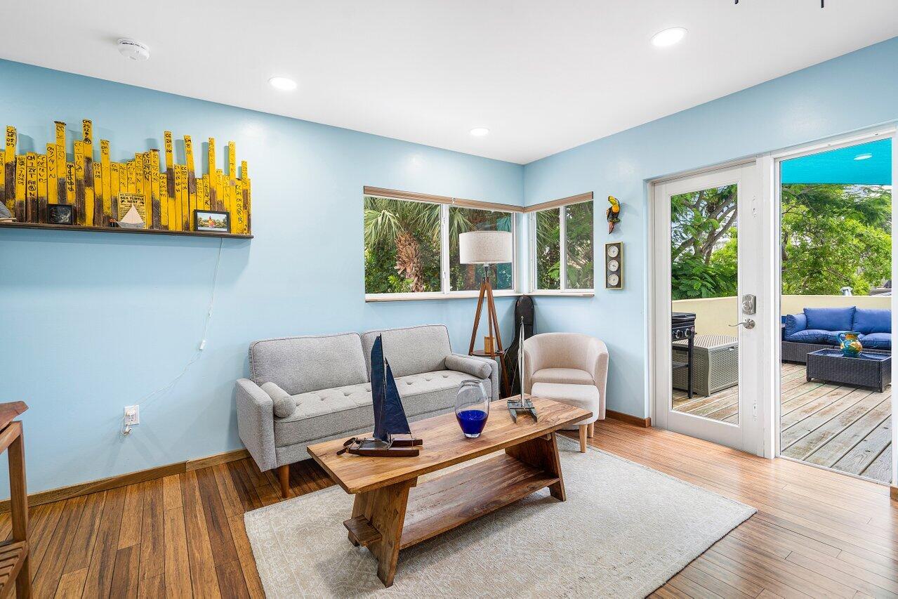 Living room with pale blue walls, a gray sofa, and glass doors opening to a patio.