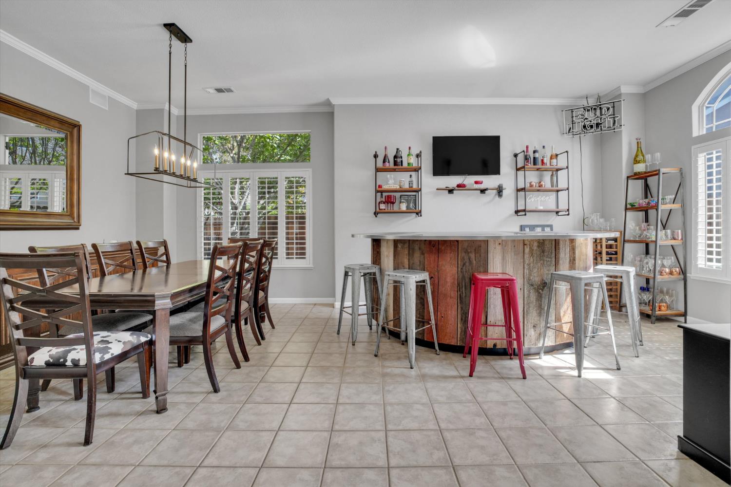 Dining room and bar with a rustic curved counter, stools, and a large wooden dining table.