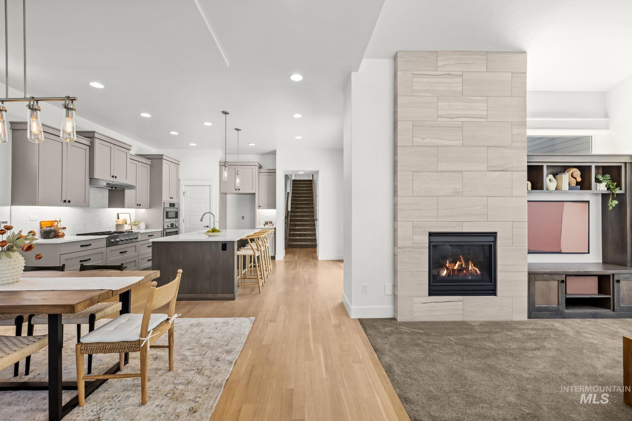 Open-plan kitchen and living room with a large island and tiled fireplace wall.