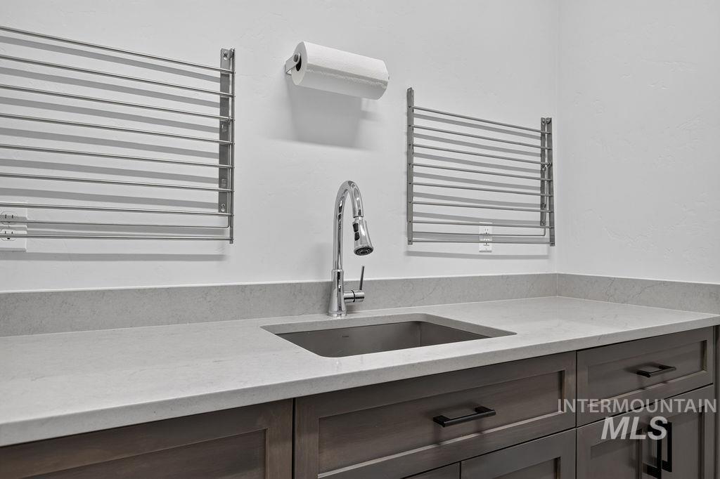Bathroom vanity with an inset sink, chrome faucet, and wall-mounted towel racks.